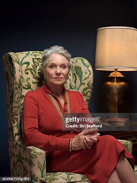 senior woman sitting in armchair, portrait - stern gold stock pictures, royalty-free photos & images