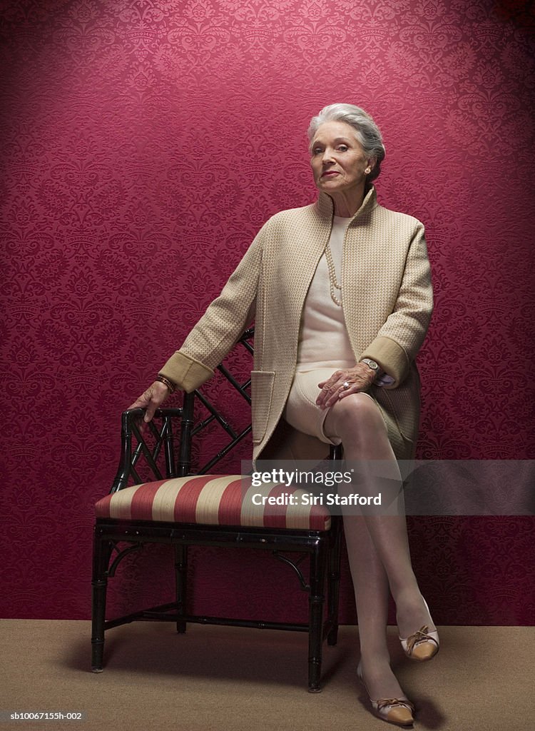 Senior woman sitting on antique chair, portrait