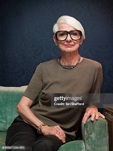 senior woman sitting on sofa wearing oversized glasses, portrait - portrait white hair studio stock pictures, royalty-free photos & images