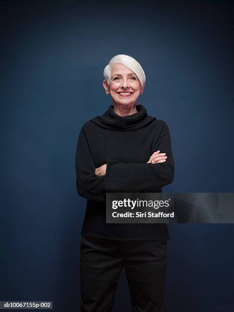 senior woman with arms crossed, portrait - senior studio portrait stockfoto's en -beelden