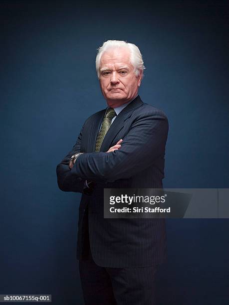 senior man with arms crossed, portrait, studio shot - man in suit stockfoto's en -beelden