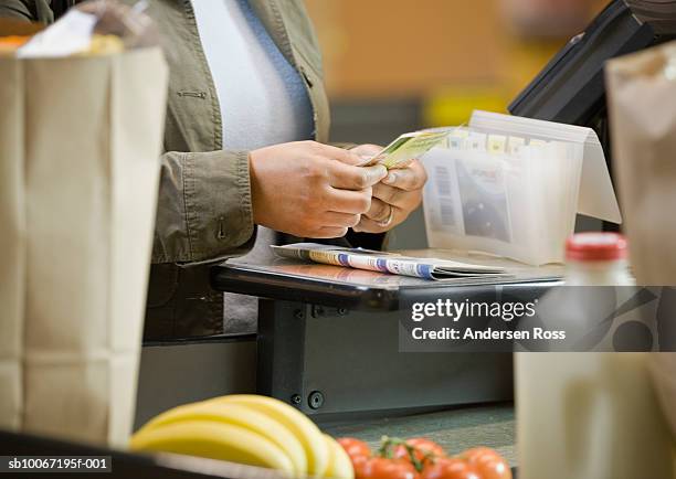 woman sorting coupons at supermarket, close-up, mid section - coupon stock-fotos und bilder