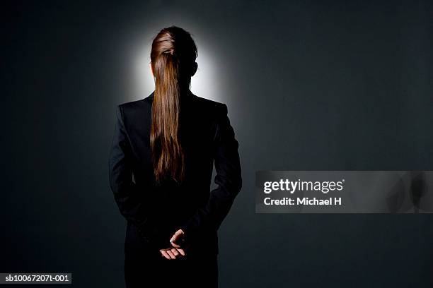 business woman with hands behind back, rear view, studio shot - flash back stock pictures, royalty-free photos & images