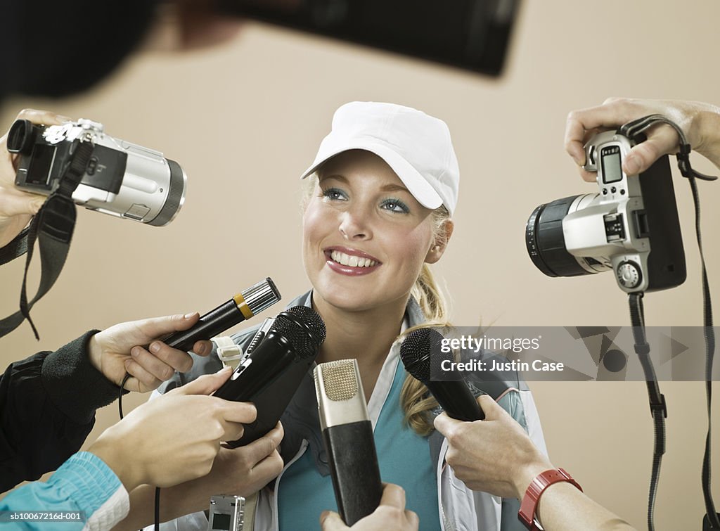 Female athlete smiling at press conference, studio shot