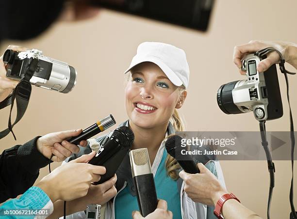 female athlete smiling at press conference, studio shot - journalist microphone stock pictures, royalty-free photos & images