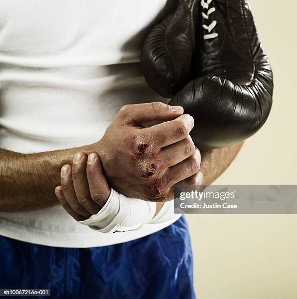 boxer with scubs on knuckles, close up, mid section, studio shot - knuckles stock pictures, royalty-free photos & images