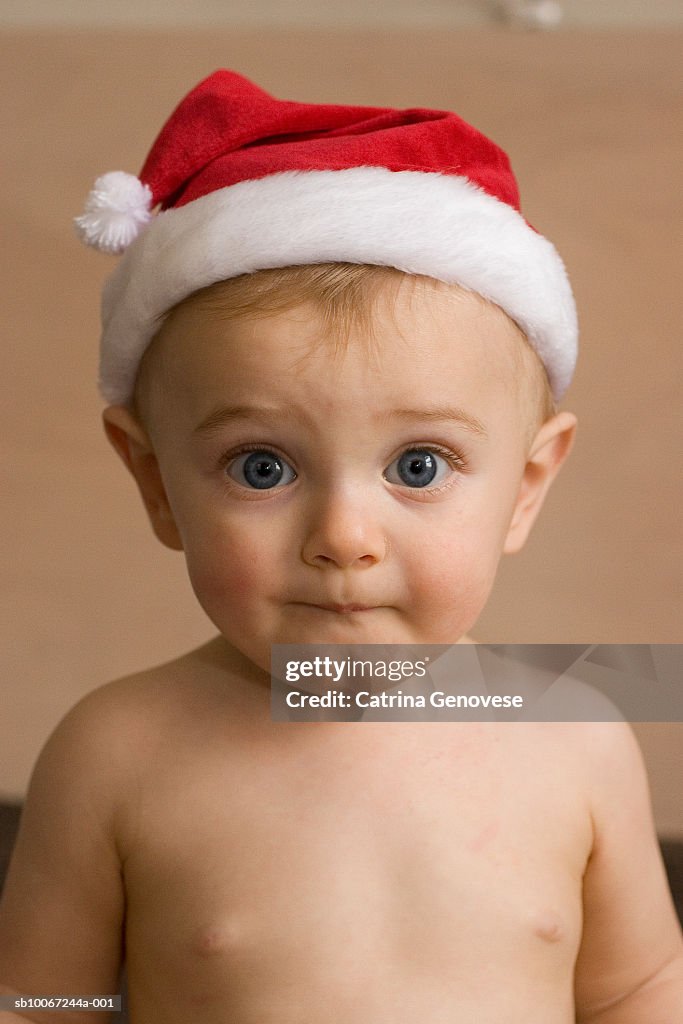 Baby boy (9-12 months) wearing Santa hat, portrait, close-up