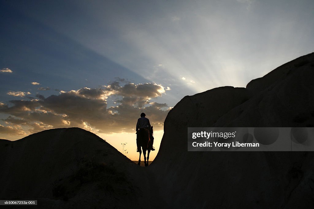 Turkey, Cappadocia, Rose Valley, silhouette of man on horseback