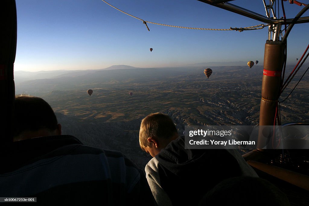 Turkey, Cappadocia, boy (12-13) in hot air balloons over countryside