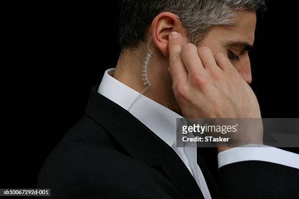 mid adult business man wearing hands-free device, close-up - security guard stock pictures, royalty-free photos & images