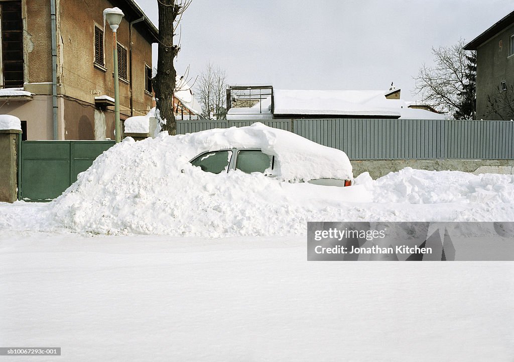 Car covered in snow drift