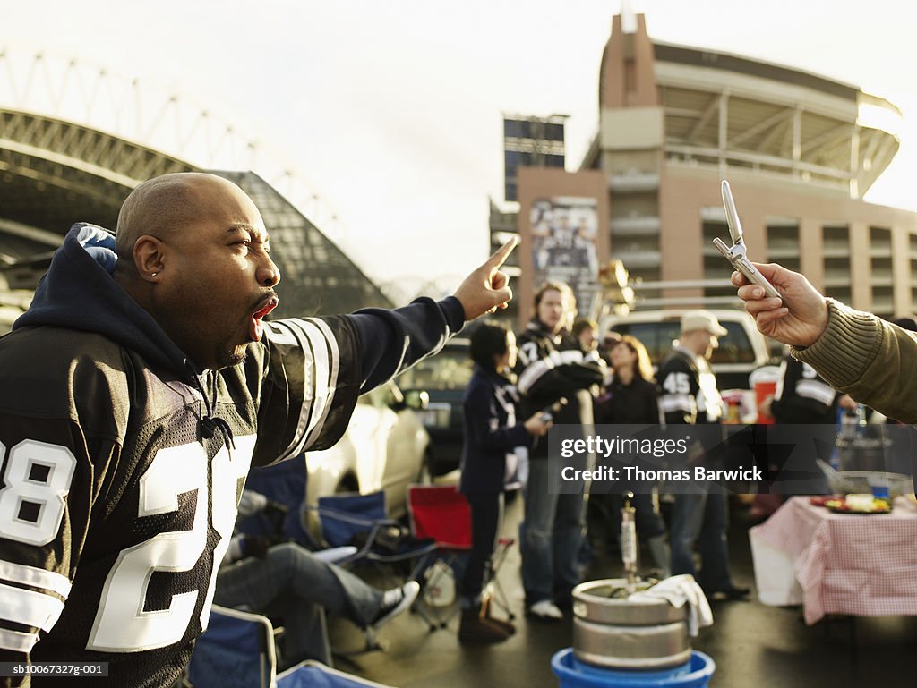 Mature men posing for photograph at tailgate party