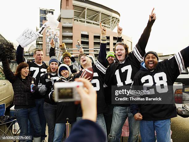 football fan posing for camera at tailgate party - tailgate stock-fotos und bilder