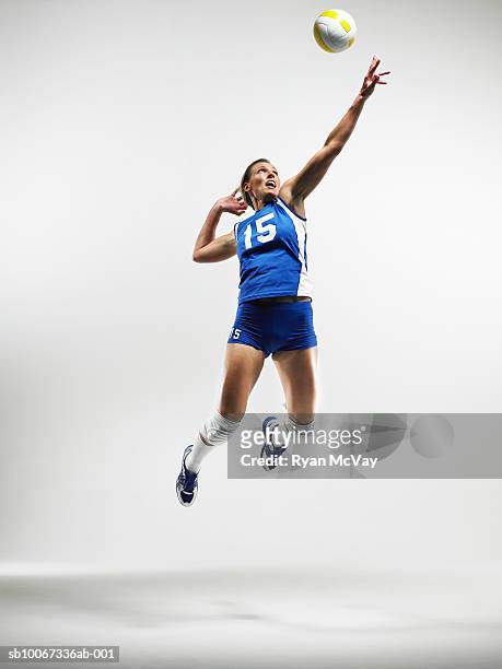 volleyball player jumping to hit ball (studio shot) - taking a shot - sport imagens e fotografias de stock