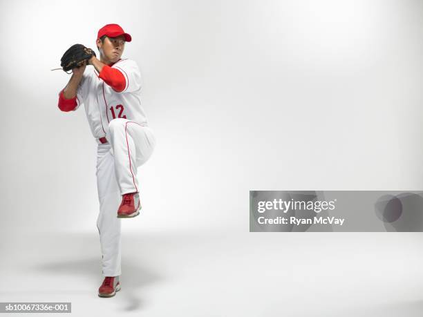 baseball pitcher winding up, studio shot - joueur-de-baseball photos et images de collection