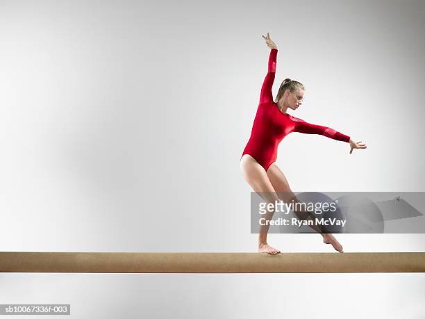 teenage gymnast (15-16) on balance beam, studio shot - acrobat stock pictures, royalty-free photos & images