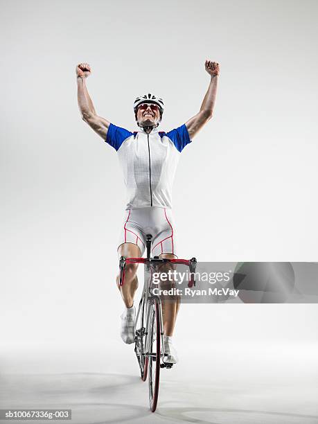 cyclist pumping fists, studio shot - personne sportive photos et images de collection