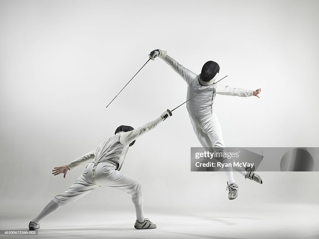 Two men fencing, studio shot