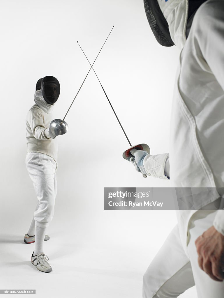 Two men fencing, studio shot
