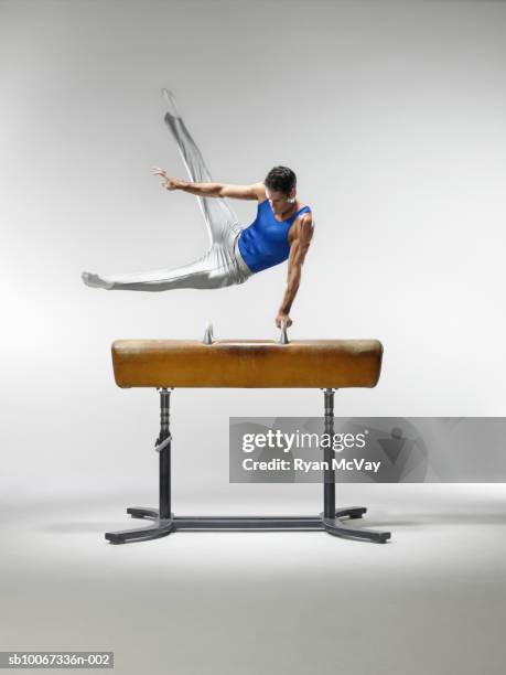 male gymnast on pommel horse, studio shot - acrobat imagens e fotografias de stock