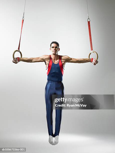 male gymnast on rings, studio shot - ringen stock-fotos und bilder