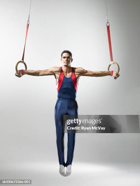 male gymnast on rings, studio shot - gymnastiek stockfoto's en -beelden