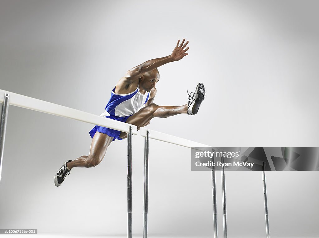 Hurdler in mid-jump (studio shot)