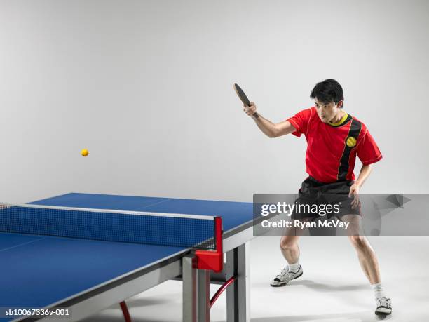 male table tennis player hitting ball (studio shot) - tennis de table photos et images de collection