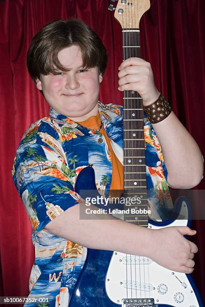 boy (12-13) holding electric guitar, portrait - chubby boy - fotografias e filmes do acervo