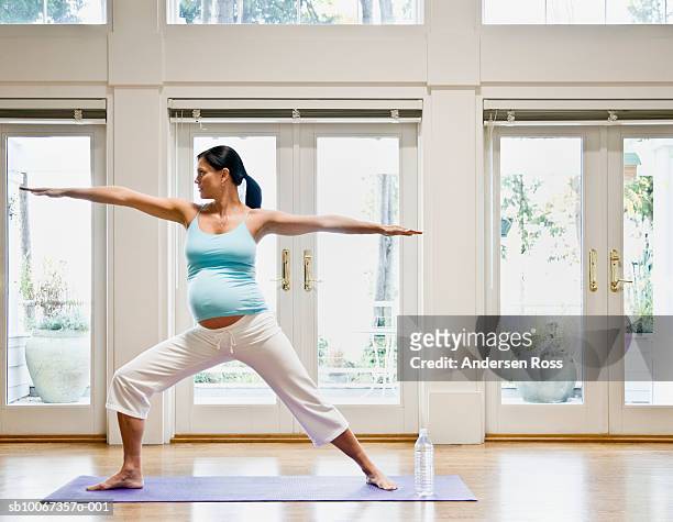 pregnant woman practicing yoga, arms out - salle yoga photos et images de collection