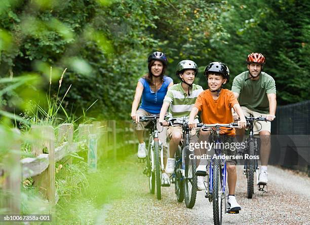 family cycling in park - four people bildbanksfoton och bilder