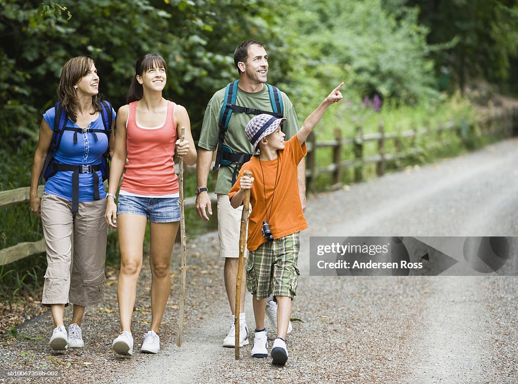 Family hiking through park, boy (10-11) pointing