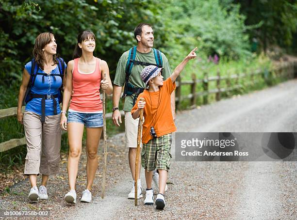family hiking through park, boy (10-11) pointing - backpacker road stockfoto's en -beelden