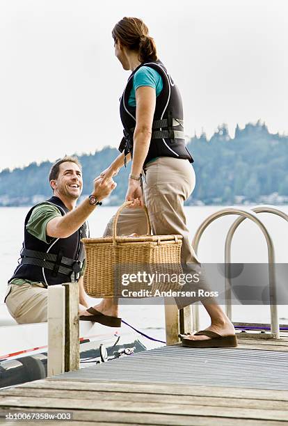 mature couple boarding on boat, smiling - motorboat stock pictures, royalty-free photos & images