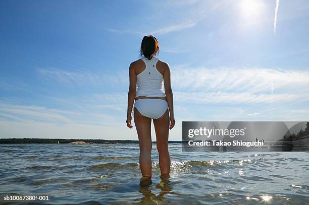 girl (16-17) standing ankle deep in lake, rear view - killbear provincial park stock pictures, royalty-free photos & images