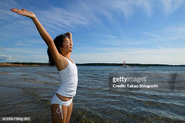 girl (16-17) standing in lake with arms outstretched - killbear provincial park stockfoto's en -beelden