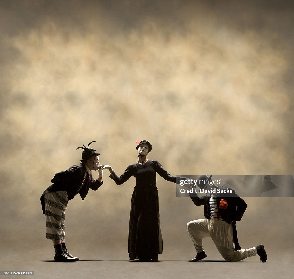 Two male mimes courting female mime