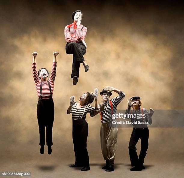 group of mimes stuck behind wall, one hanging, another sitting on top - mime stock pictures, royalty-free photos & images