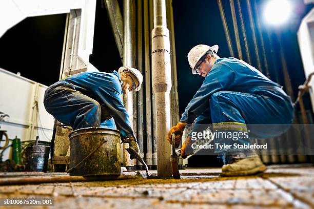 two oil workers working on drilling rig - oil rig worker stock pictures, royalty-free photos & images