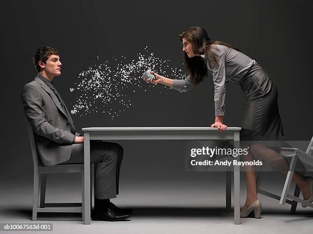 businesswoman throwing paper pieces on man, side view (digital composite) - leaning over stock-fotos und bilder