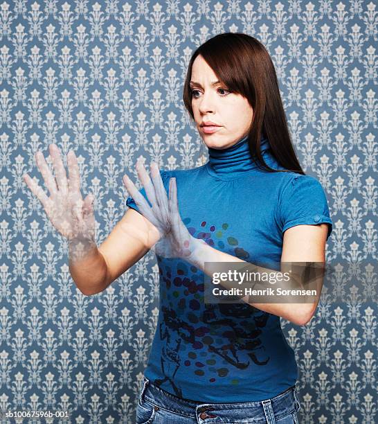 woman looking at vanishing hands (digital composite) - invisible man stock-fotos und bilder