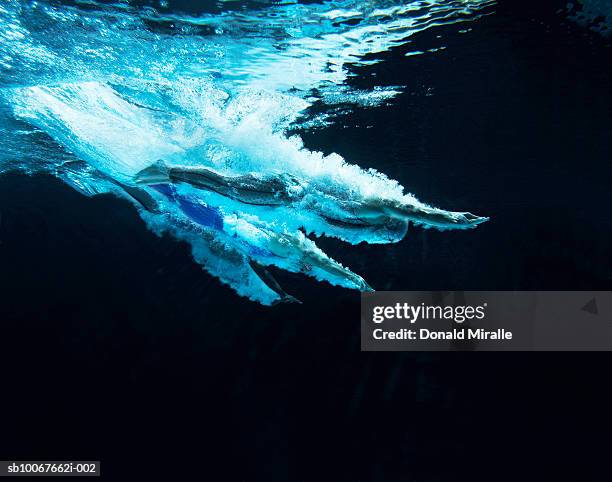 underwater view of swimmers - impact stock pictures, royalty-free photos & images