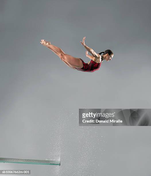 diver in mid-air - jump in pool stock-fotos und bilder