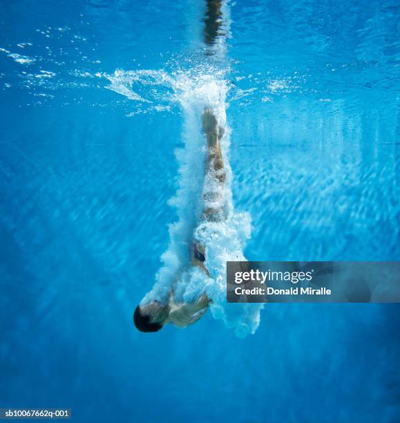 underwater view of diver entering water - aquatic sport stock-fotos und bilder