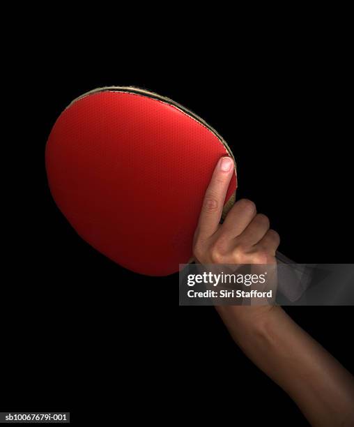 hand holding table tennis paddle, on black background - table tennis bat stock pictures, royalty-free photos & images