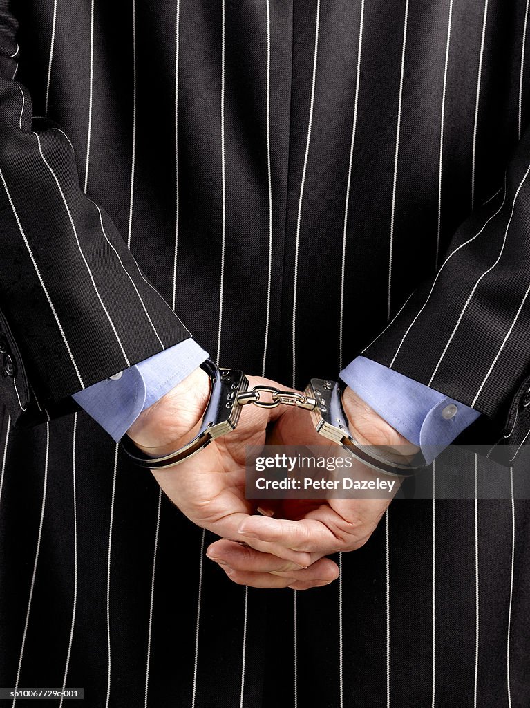 Businessman hand cuffed, close-up
