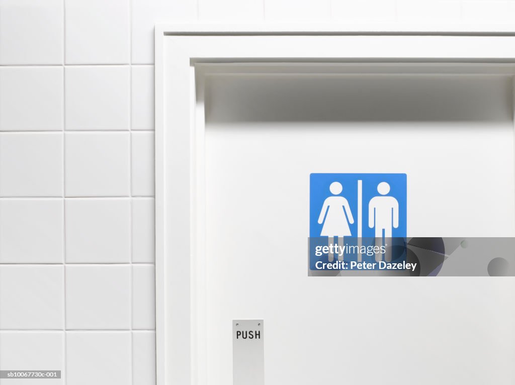 Female and male sign on toilet door, close-up