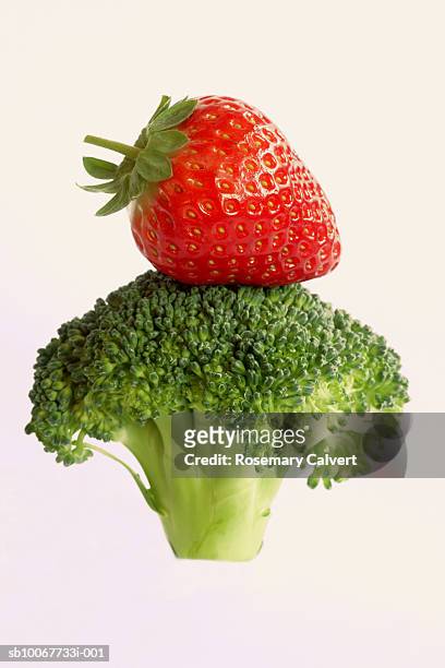 broccoli with strawberry balanced in stack - broccoli on white stock-fotos und bilder