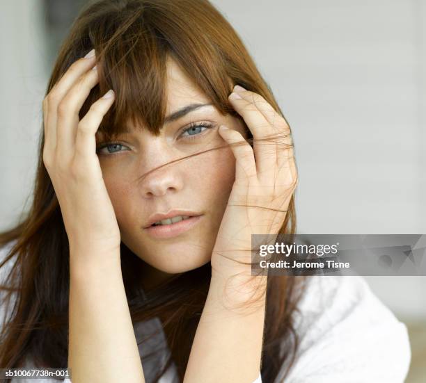 young woman with head in hands, portrait - despeinado fotografías e imágenes de stock