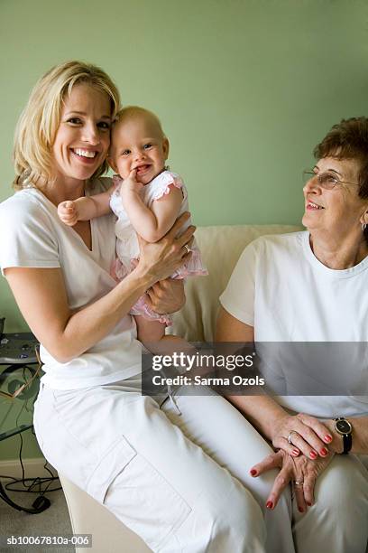 grandmother, mother and baby girl (9 months) on sofa - baby 3 months stock-fotos und bilder